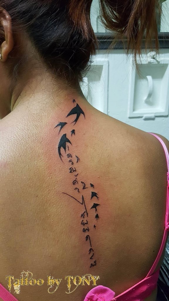 Tatouage écriture oiseau dos